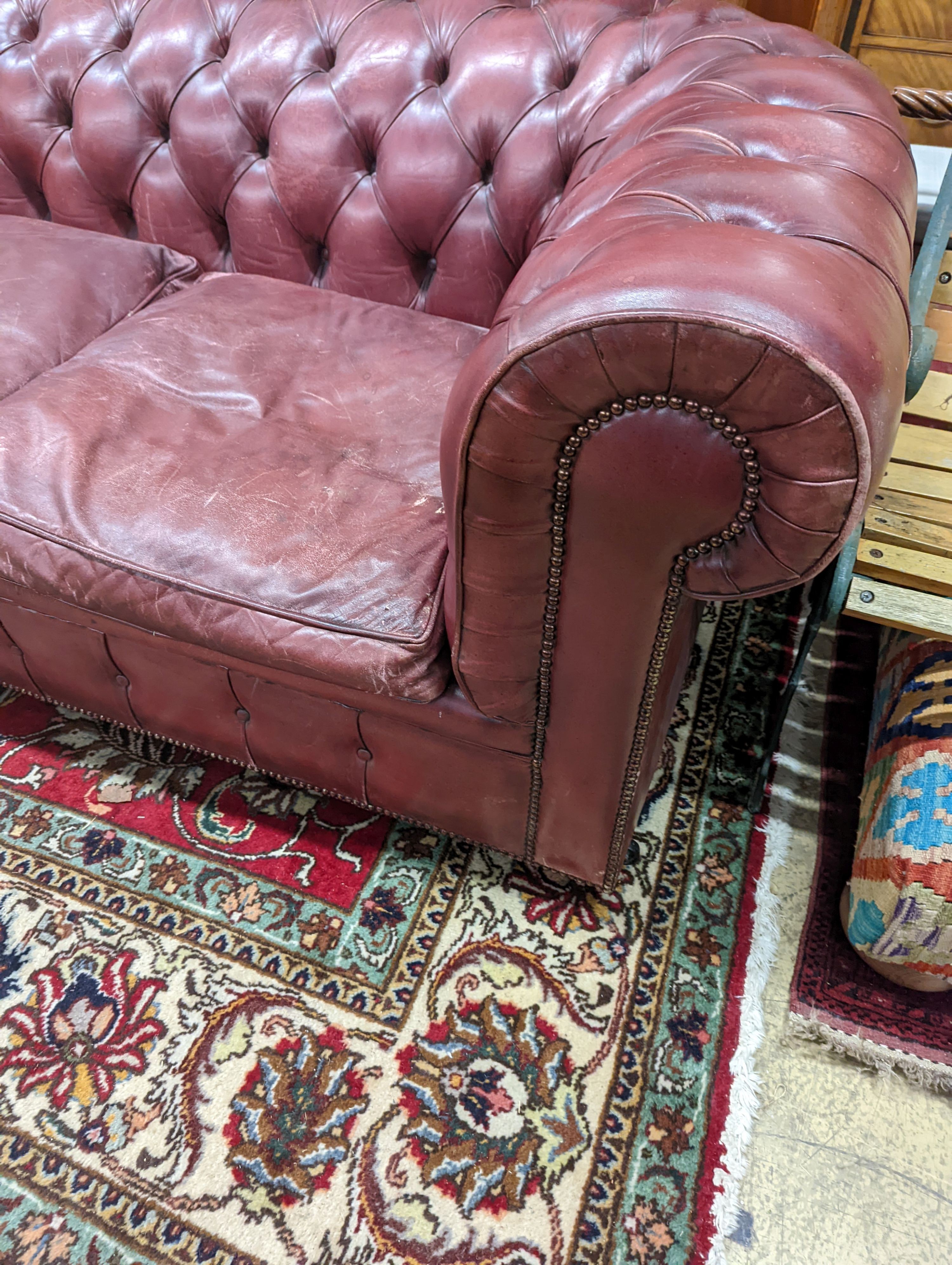 A Victorian style buttoned burgundy leather Chesterfield settee, length 172cm, depth 90cm, height 73cm
